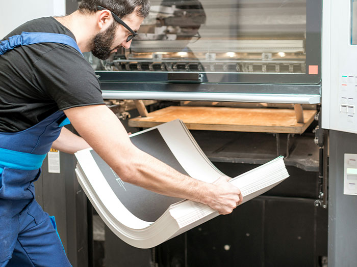 Worker operating a printing machine, representing behind-the-scenes in the entertainment industry.