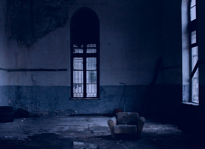 Dimly lit, abandoned room with a single armchair, symbolizing Hollywood's dark entertainment industry secrets.