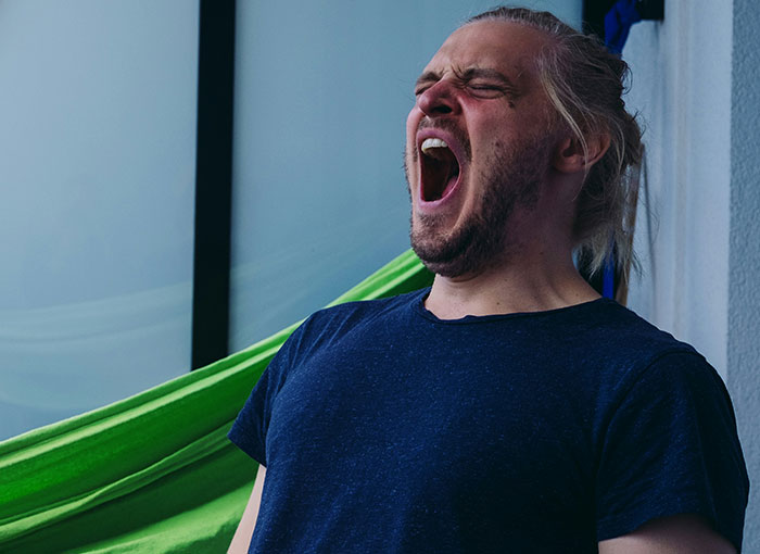 Person in a relaxed setting, wearing a navy shirt, expressing emotion. Entertainment industry insights.