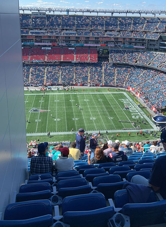 Stadium view of a football field with spectators, highlighting potential regret over spending money on expensive tickets.