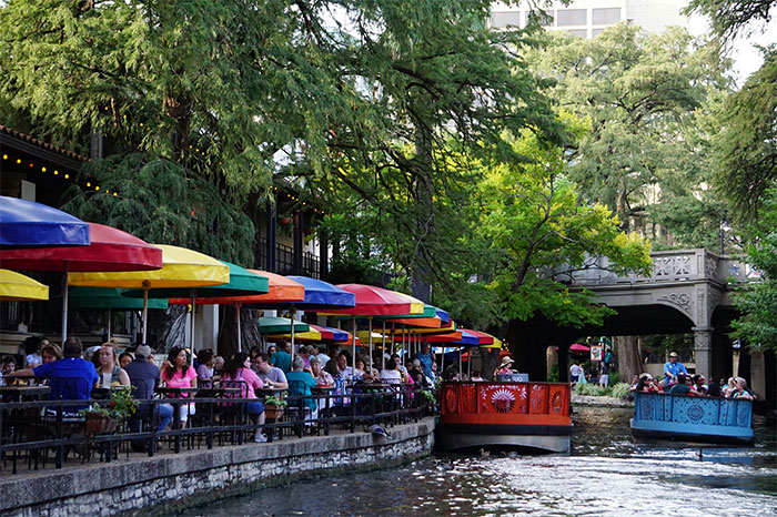 Colorful riverside cafes along a bustling waterway, highlighting hyped travel destinations and tourist activity.