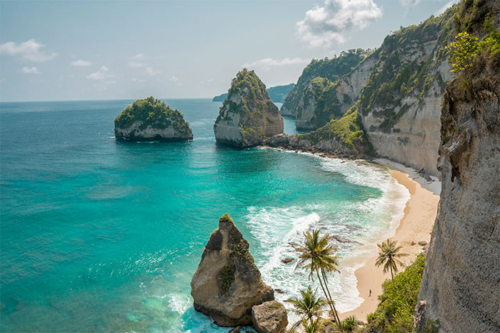 Tropical beach with blue water and rock formations, a hyped travel destination.
