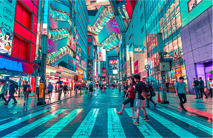 Bustling street in Tokyo with neon lights and people crossing, a hyped travel destination.