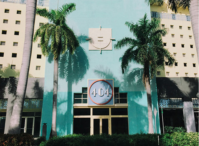 Tourist destination with "404" sign, palm trees in the foreground, disappointing experience.