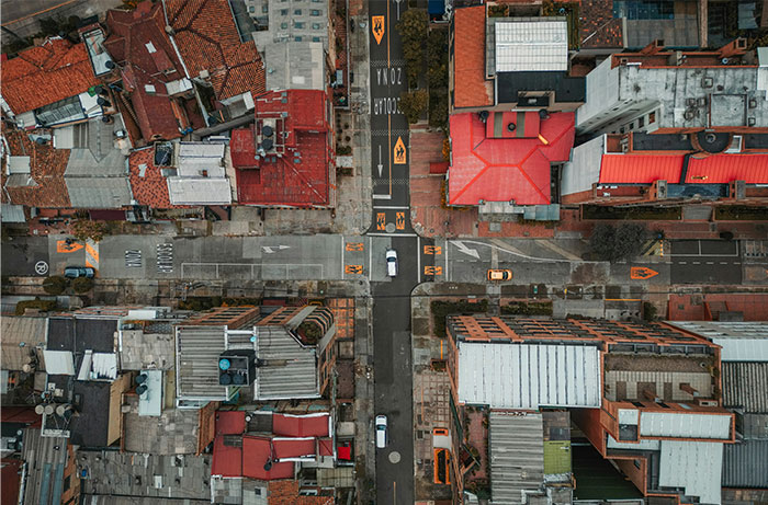 Aerial view of a city intersection with red-roofed buildings, focusing on travel destinations.