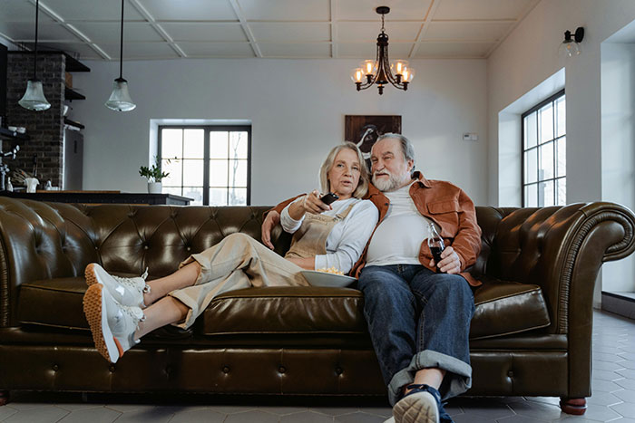 Senior couple relaxing on a couch, enjoying a quiet moment together at home.