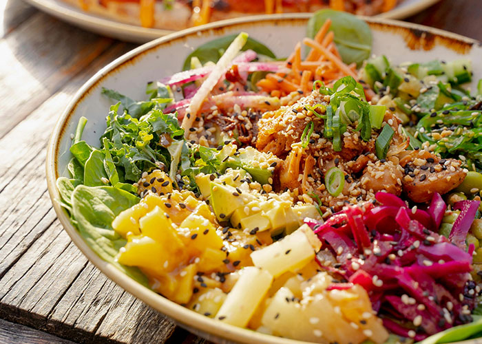 Colorful salad bowl with mixed greens, pineapple, radishes, and sesame seeds, embodying life realities through healthy choices.