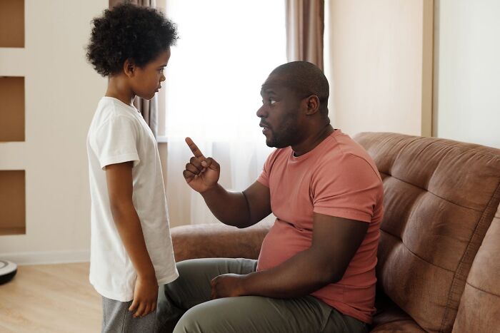 Father and son in discussion on family secrets, seated in a cozy living room.