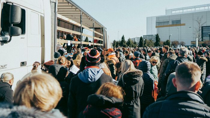 A large crowd gathers around an open truck, highlighting public interest in conspiracy theories.