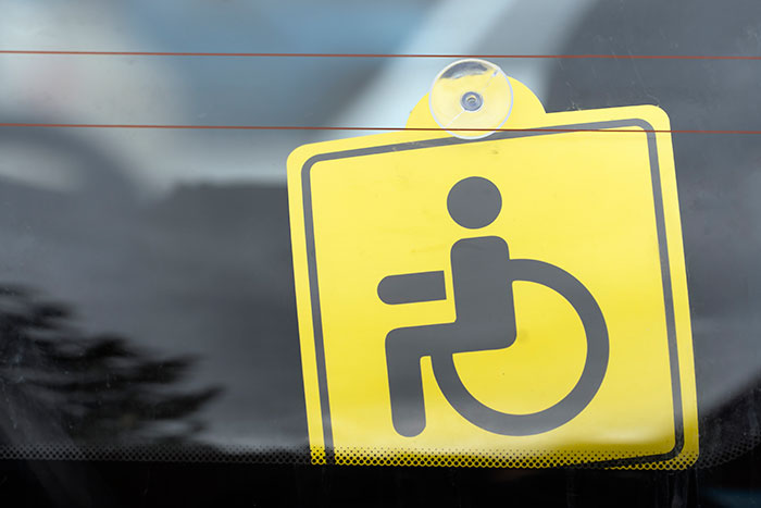 Handicapped parking sign visible through a car window.
