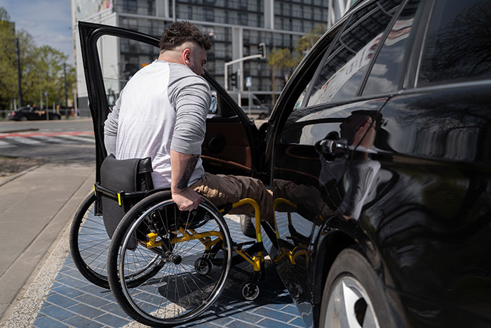 Man in wheelchair confronting a car parked in a handicapped spot.
