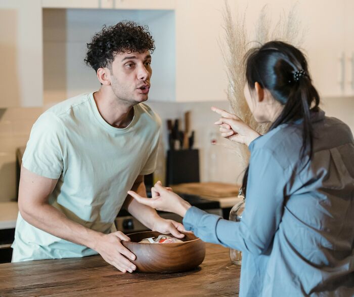 Couple arguing in a kitchen, highlighting relationship tension and challenges.