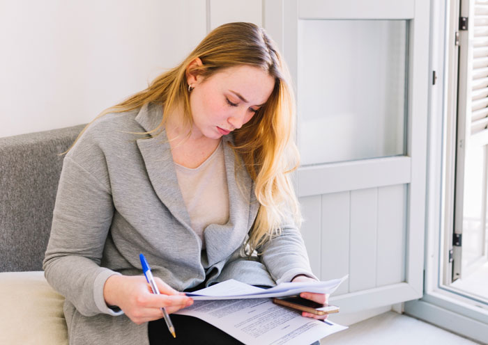 Woman reviewing documents at home, related to refusing to pay rent. Woman reviewing documents at home, related to refusing to pay rent.