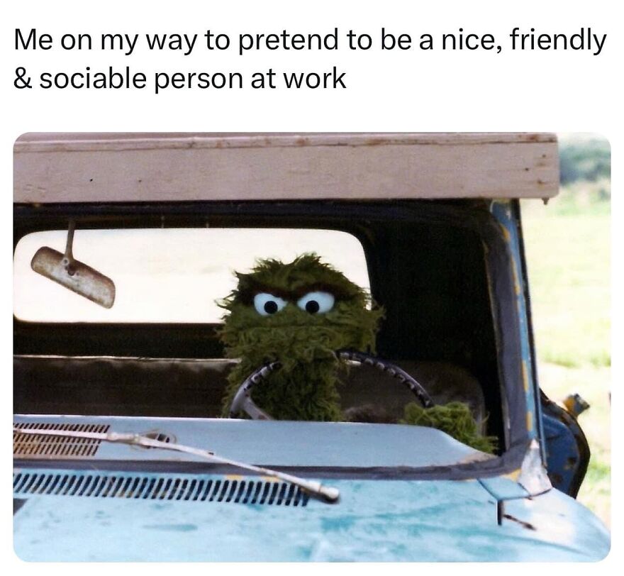 Funny meme of furry green character driving a car, humorously pretending to be social at work.