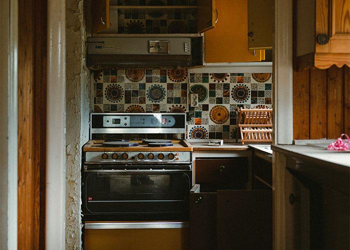 Renovated kitchen with vintage oven and colorful tiled backsplash in an empty condo. Renovated kitchen with vintage oven and colorful tiled backsplash in an empty condo.