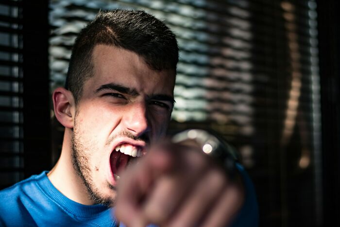 A man in a blue shirt, with an intense expression, points directly at the camera, evoking a cringy "nice guy" vibe.