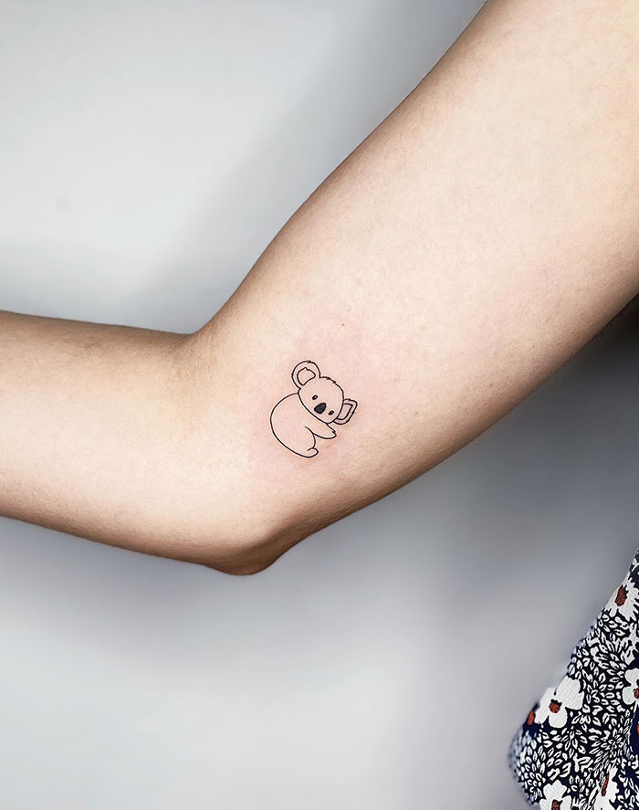 Minimalist koala tattoo design on a woman's arm, showcasing subtle tattoo ideas.