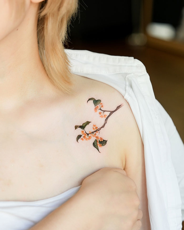 Cherry blossom tattoo on woman's shoulder, showcasing subtle and elegant design ideas.
