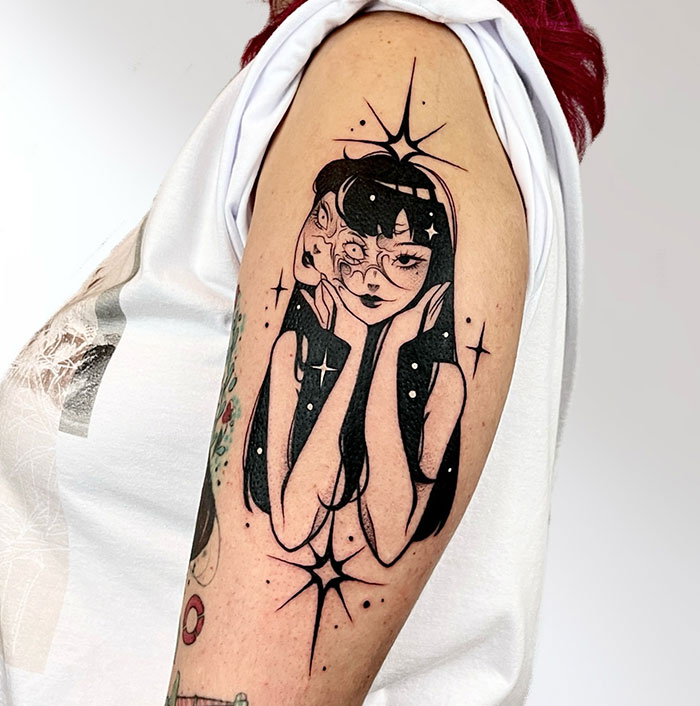 Tattoo of a woman with two faces on an arm, showcasing daring and artistic design elements.
