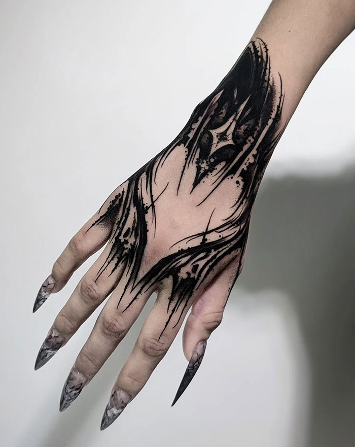 Intricate black hand tattoo design for women, showcasing daring artistic flair.