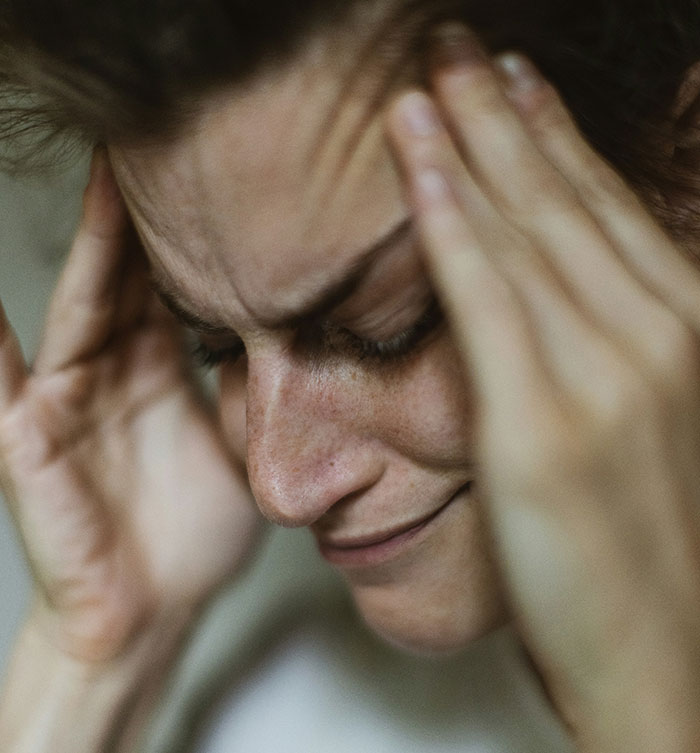 A stressed mom holding her head, illustrating a reaction to a twins' birthday invitation issue. A stressed mom holding her head, illustrating a reaction to a twins' birthday invitation issue.
