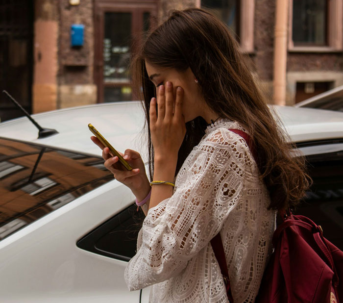 Woman in distress reading on her phone, possibly about a last-minute cancellation of a family cruise. Woman in distress reading on her phone, possibly about a last-minute cancellation of a family cruise.
