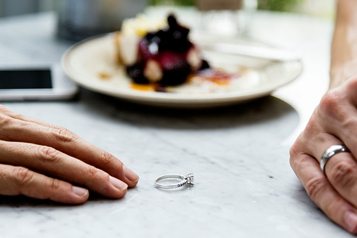 A wedding ring on a table between two people, symbolizing conflict over family inheritance decisions. A wedding ring on a table between two people, symbolizing conflict over family inheritance decisions.