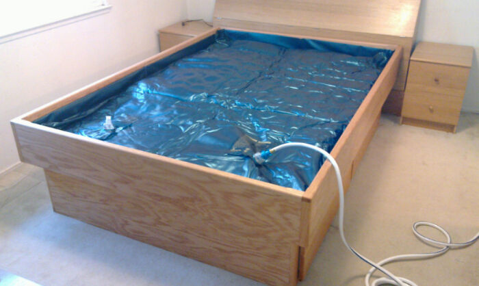 Waterbed being filled with a hose, illustrating really messed up moments in home maintenance.