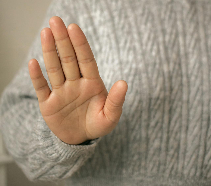 Hand making a stop gesture, illustrating boundary-setting in family dynamics. Hand making a stop gesture, illustrating boundary-setting in family dynamics.