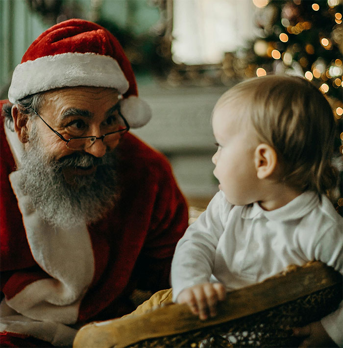 Santa Claus interacting with a curious child, festive Christmas setting in the background. Santa Claus interacting with a curious child, festive Christmas setting in the background.