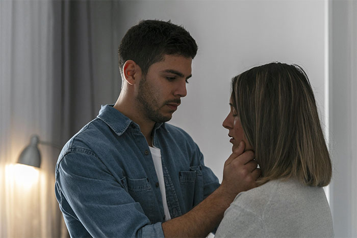 Fianc&eacute; gently holds bride's face, discussing wedding dress color to keep his mom comfortable.