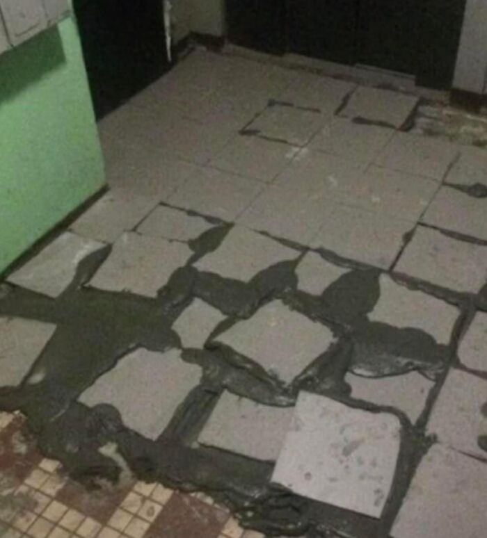 Poorly laid tiles with uneven grout, showcasing a funny construction fail.