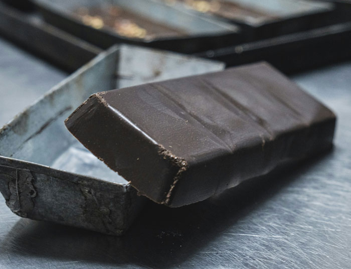 Dark chocolate bar on a metal tray, close-up view.