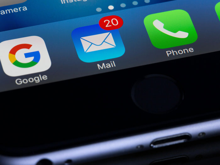 Close-up of smartphone screen showing unread mail notifications.