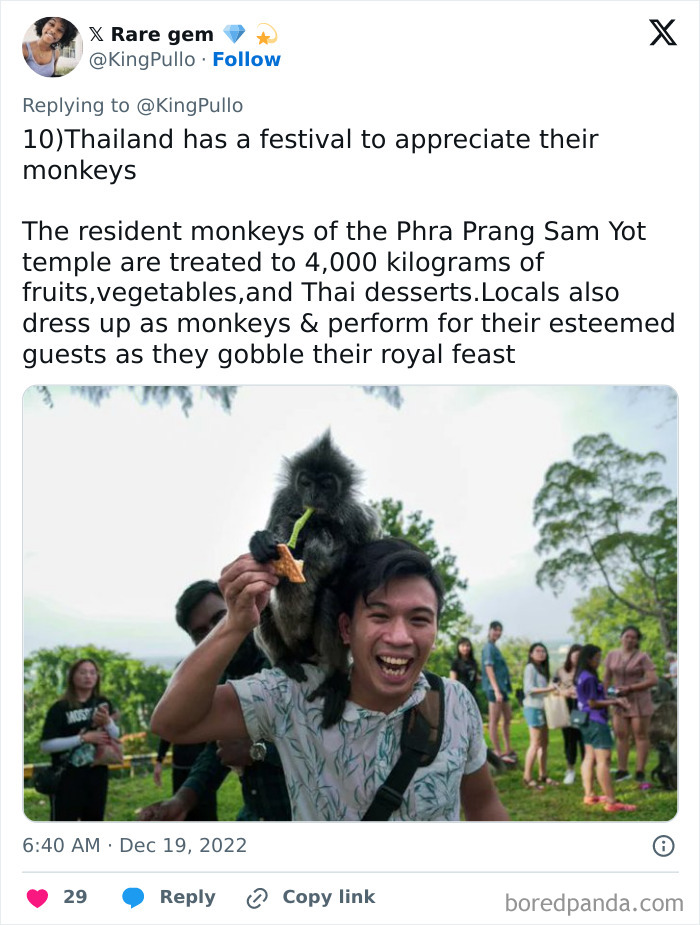 Man with a monkey on his shoulder at Thailand festival, rare facts about people and places captured outdoors with group nearby.