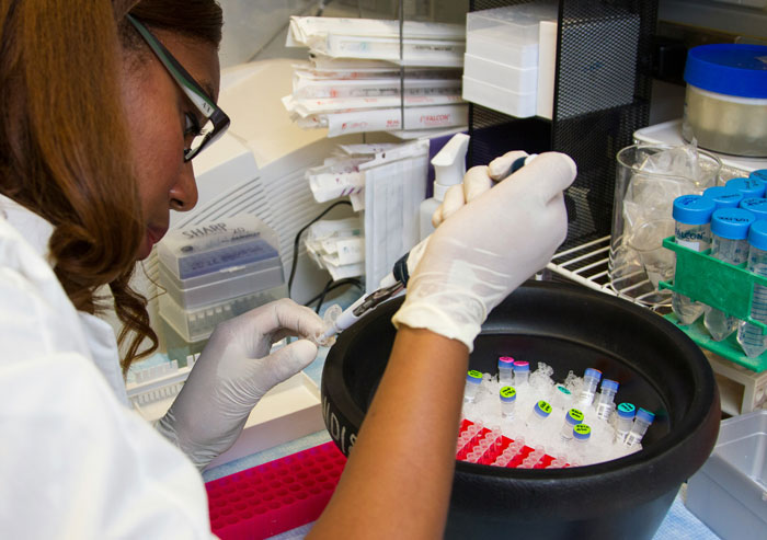 Scientist in a lab, using pipette for sample analysis, emphasizes the importance of taking security measures seriously.