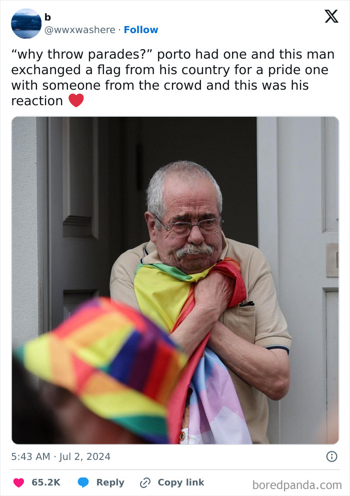 Man holding a pride flag with an emotional expression, showcasing online support and wholesome community spirit.