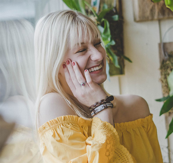 Smiling woman wearing a yellow blouse, representing clever revenge in a lighthearted context. Smiling woman wearing a yellow blouse, representing clever revenge in a lighthearted context.