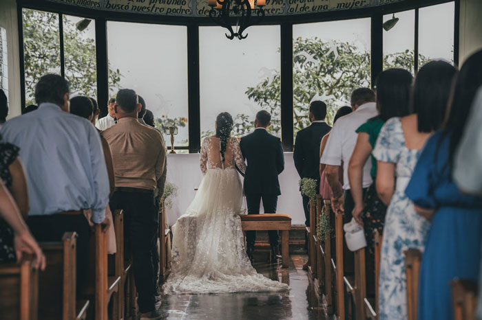 Wedding ceremony in a church, bride in a lace gown and groom at the altar, surrounded by guests. Wedding ceremony in a church, bride in a lace gown and groom at the altar, surrounded by guests.