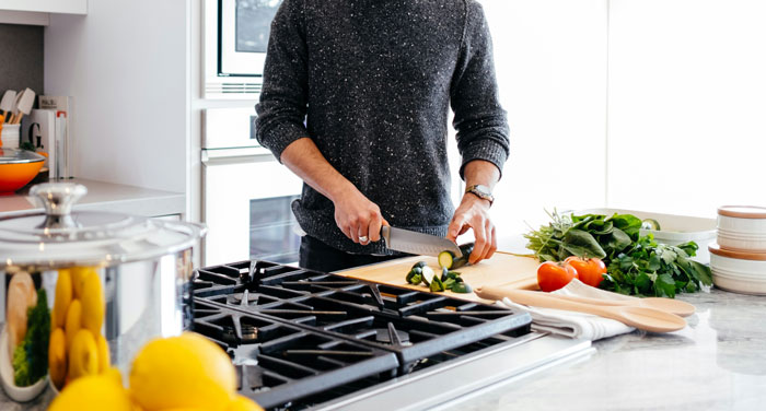 Man slicing vegetables in a modern kitchen, emphasizing baking skills and appreciation for Taylor Swift. Man slicing vegetables in a modern kitchen, emphasizing baking skills and appreciation for Taylor Swift.