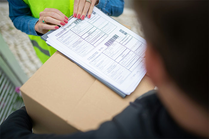 Delivery person checks forms on a package, highlighting neighbor dispute and clever revenge theme. Delivery person checks forms on a package, highlighting neighbor dispute and clever revenge theme.