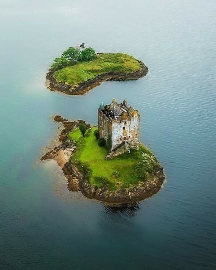 Scottish island with an ancient stone castle surrounded by water and greenery.