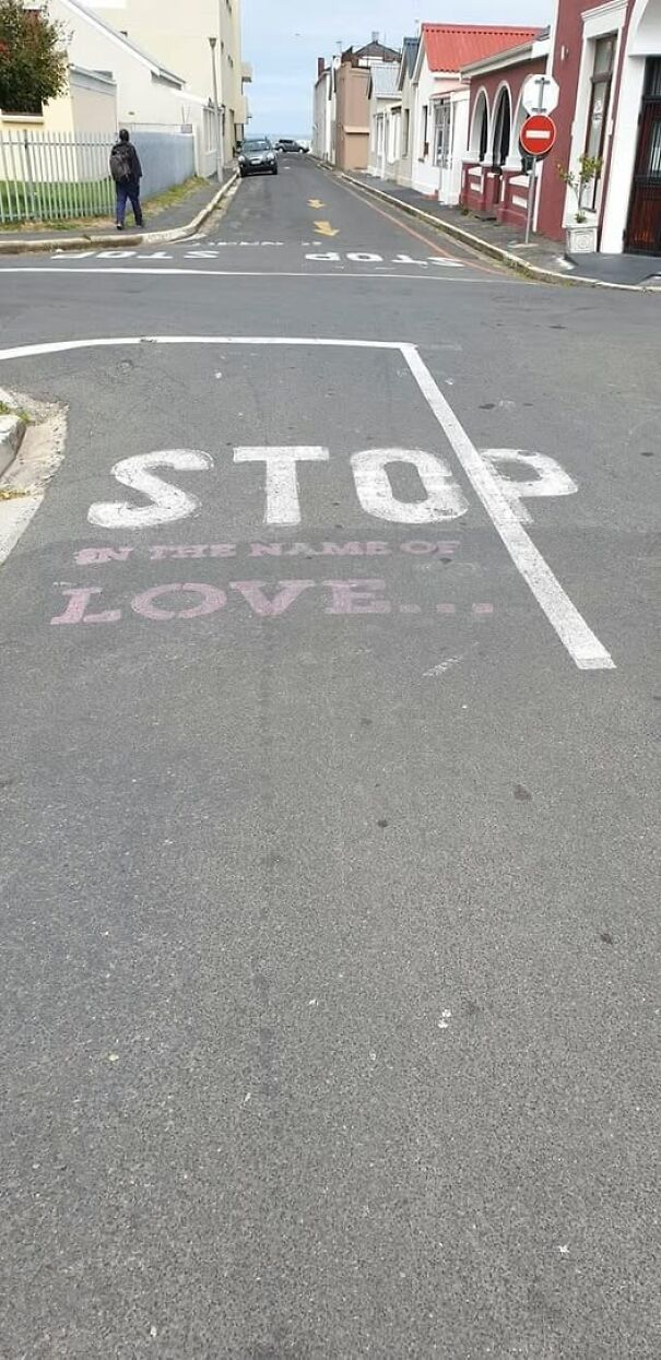 Weird sign on road reads "STOP in the name of LOVE" with a humorous twist.