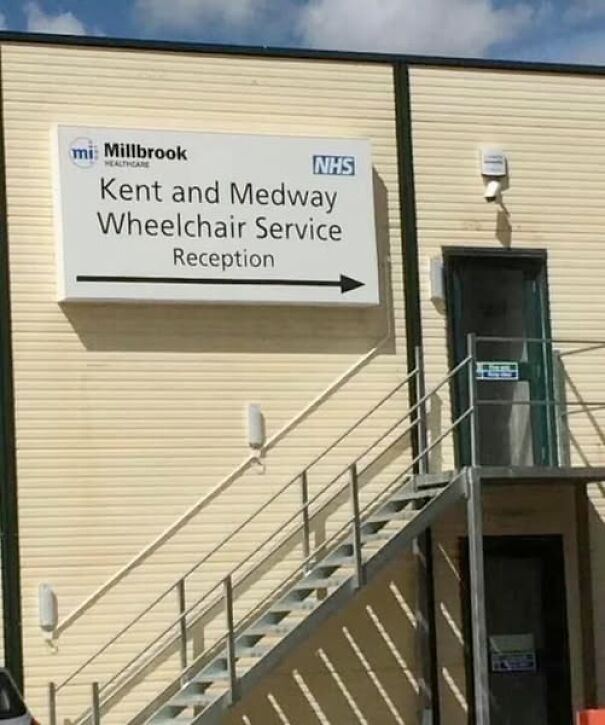 Sign for Kent and Medway Wheelchair Service, ironically placed up a flight of stairs.