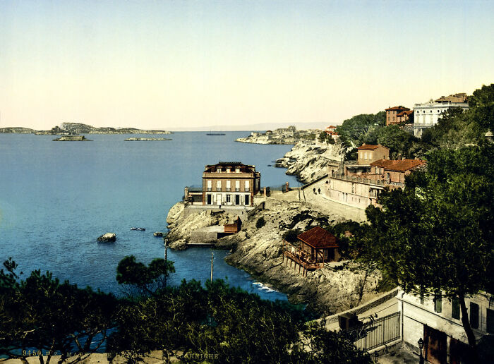 Historic coastal landscape in color showing how the world appeared 100 years ago, with cliffs and buildings by the sea.