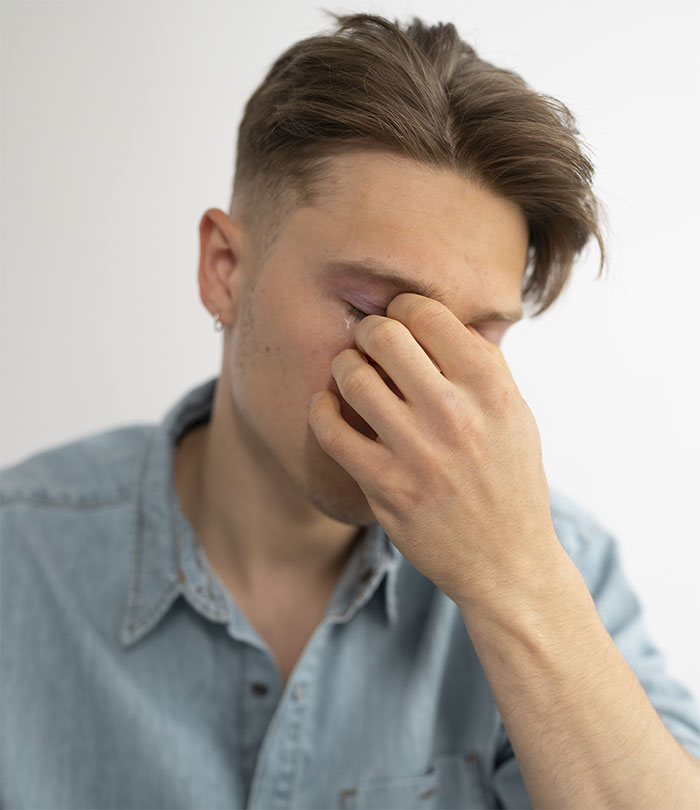 Man in denim shirt looks stressed, highlighting wedding dress dilemma.