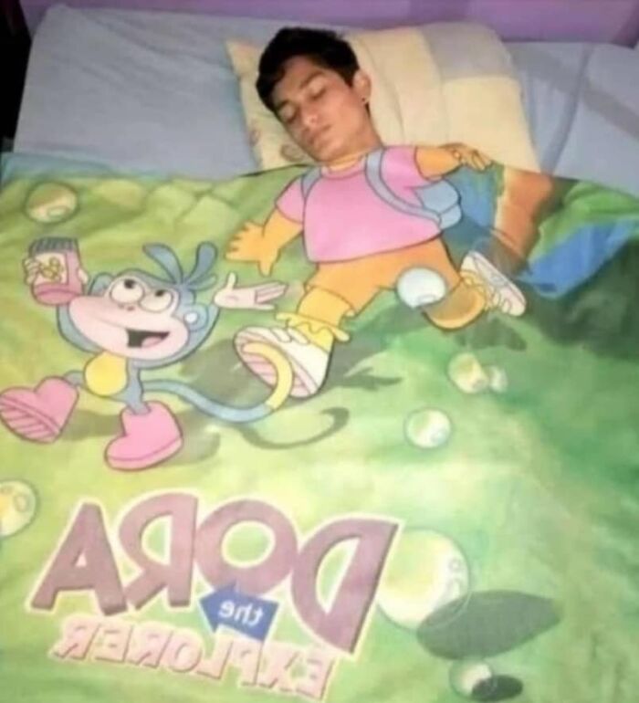 Person asleep under a blanket featuring Dora the Explorer, creating a surreal album cover vibe.