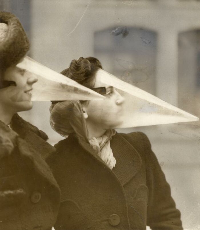Women wearing unique cone-shaped face shields, showcasing strange inventions.