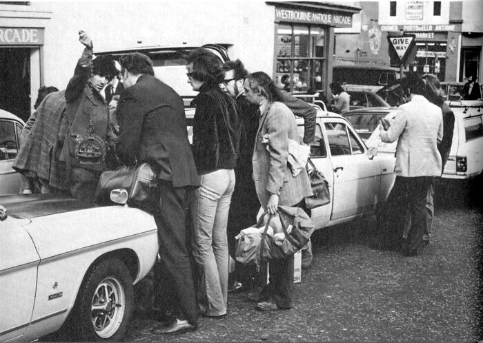 1973 street scene with people gathered around cars near Westbourne Antique Arcade.