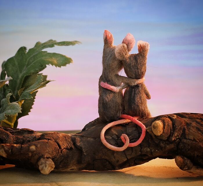 Two mice embrace on a branch under a colorful sunset, part of Maggie Rudy's miniature Mouseland.